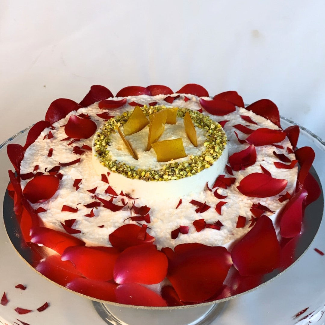 Decorative cake with red petals and gold elements on a white background