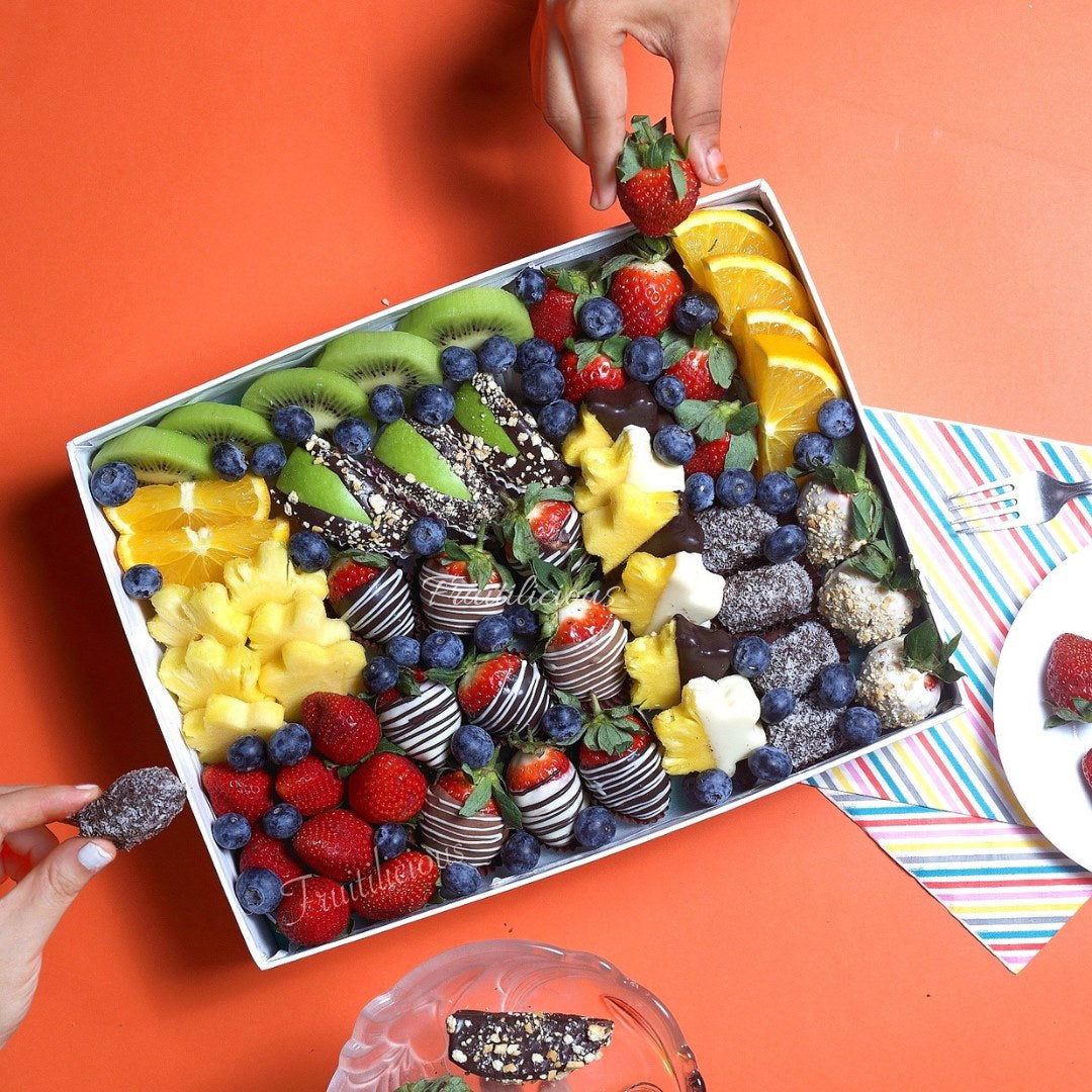 Assorted fruit and chocolate tray on an orange background